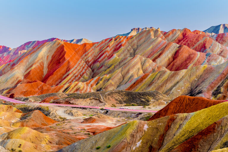 Amazing scenery of Rainbow mountain and blue sky background in sunset. Zhangye Danxia National Geopark, Gansu, China. Colorful landscape, rainbow hills, unusual colored rocks, sandstone erosion